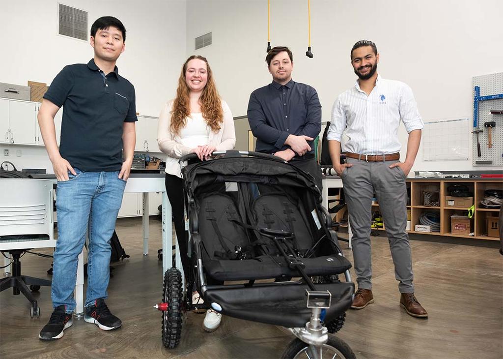 Three male students and one female student pose in front of their autonomous chair